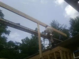 Carpenter setting a ridge beam over a new addition frame — Ice Dam Removal by Roofing Brothers in Pottersdale