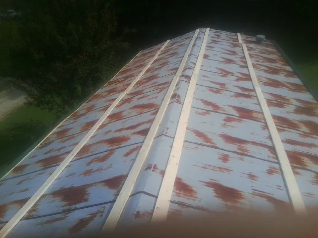 Rusted metal roof panels with new wood purlins before replacement — Storm Damage Roof Repair in Pottersdale by Roofing Brothers