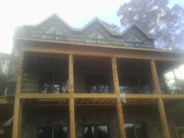 Dormers and porch framing on a large log home under construction — Roof Coating work by our crew in Pottersdale