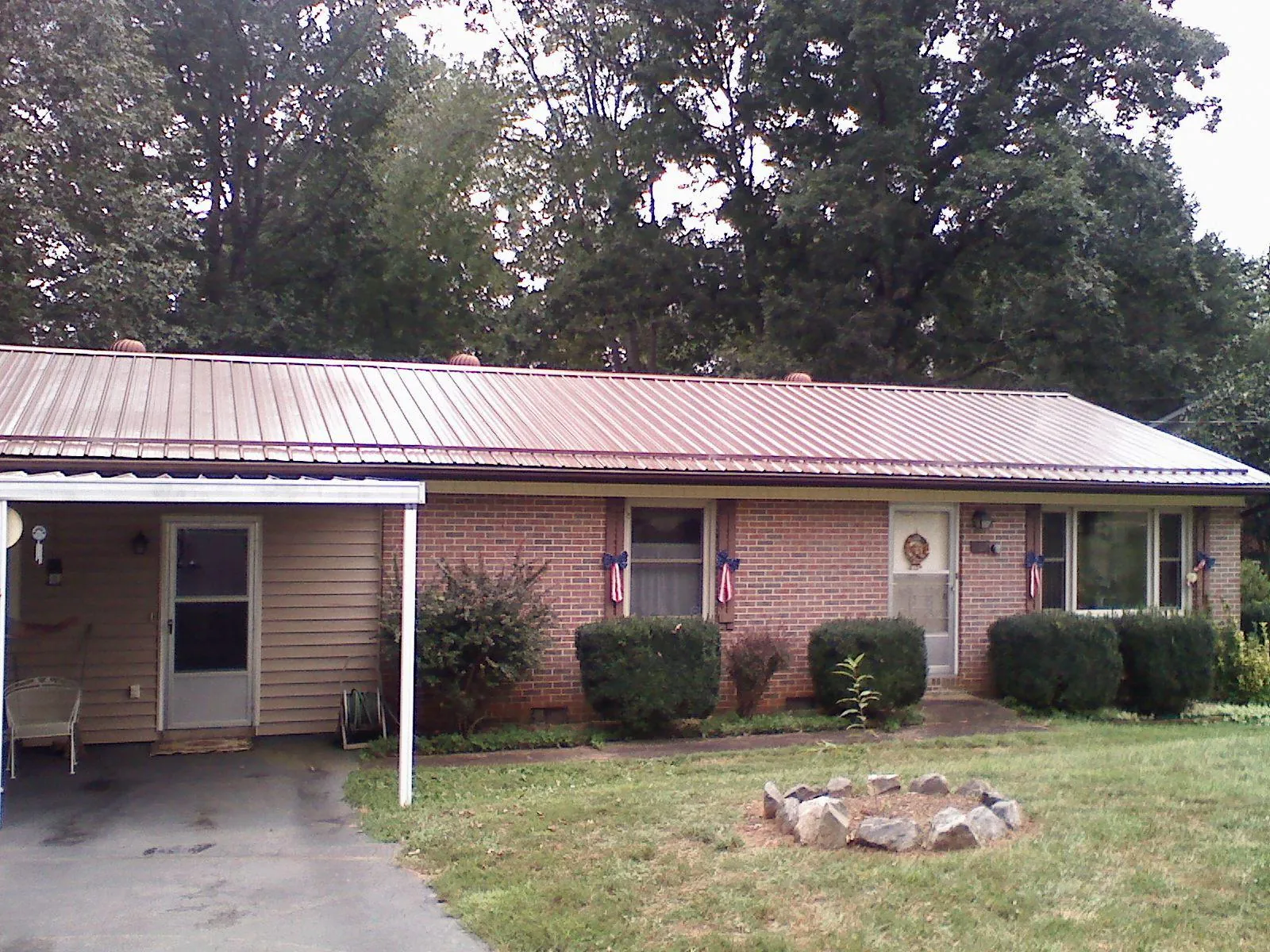 Bronze metal roof and carport on a brick ranch home — Roof Repair work by our crew in Pottersdale